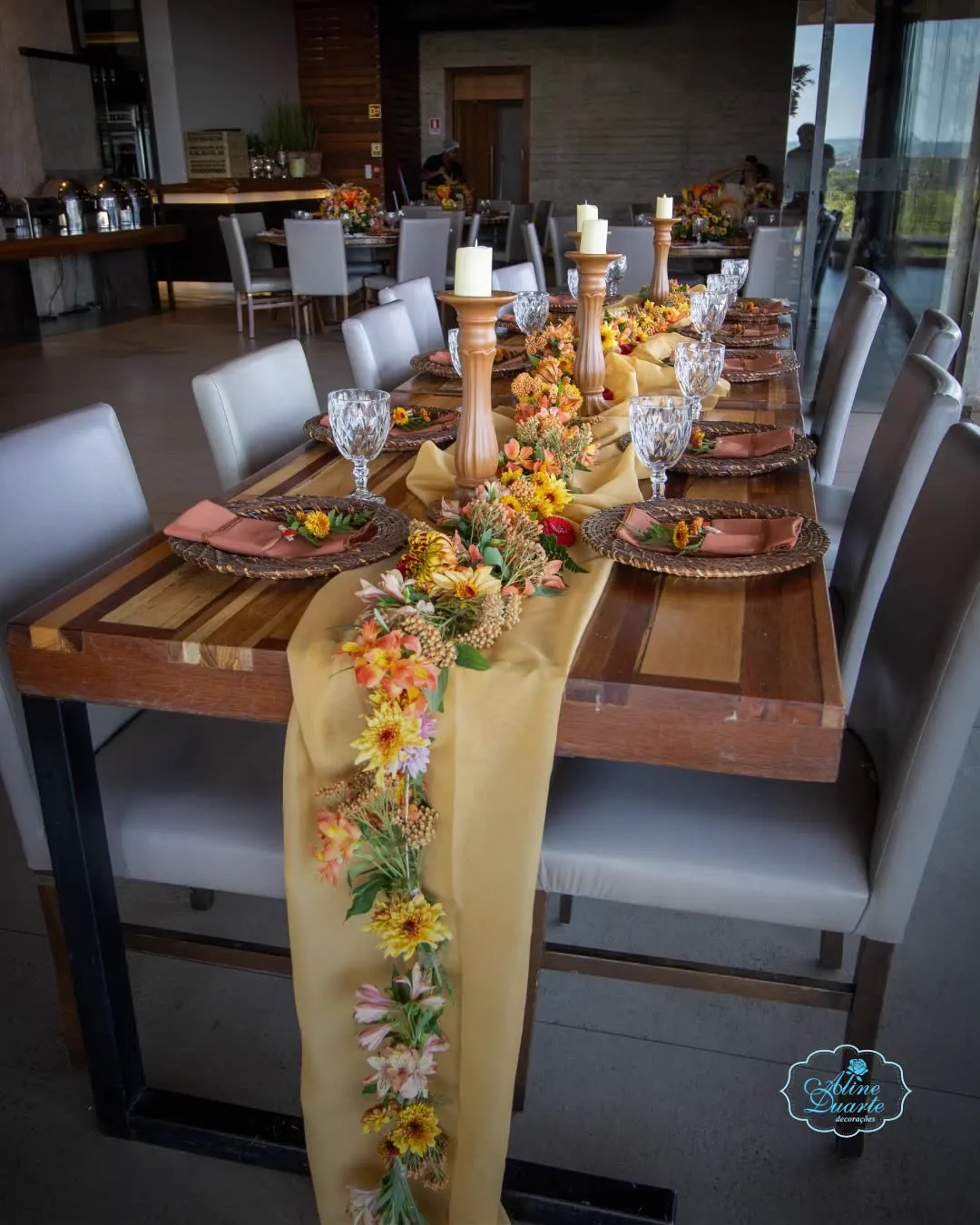 Mesa posta longa com caminho de flores e castiçais